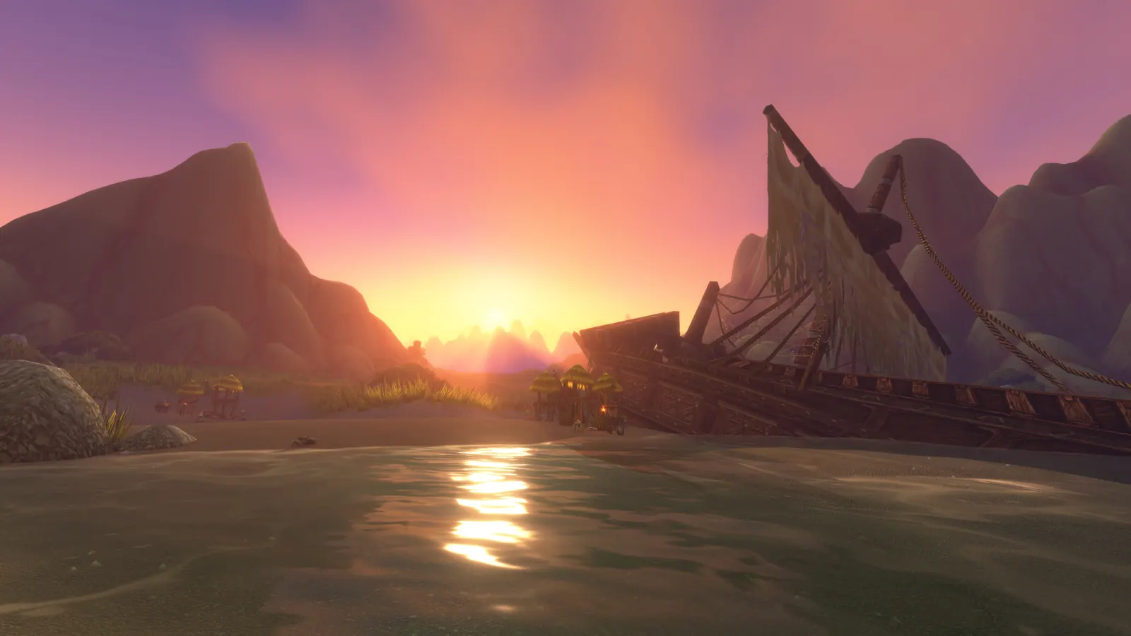 The wreck of a wooden ship on a riverbank at sunset