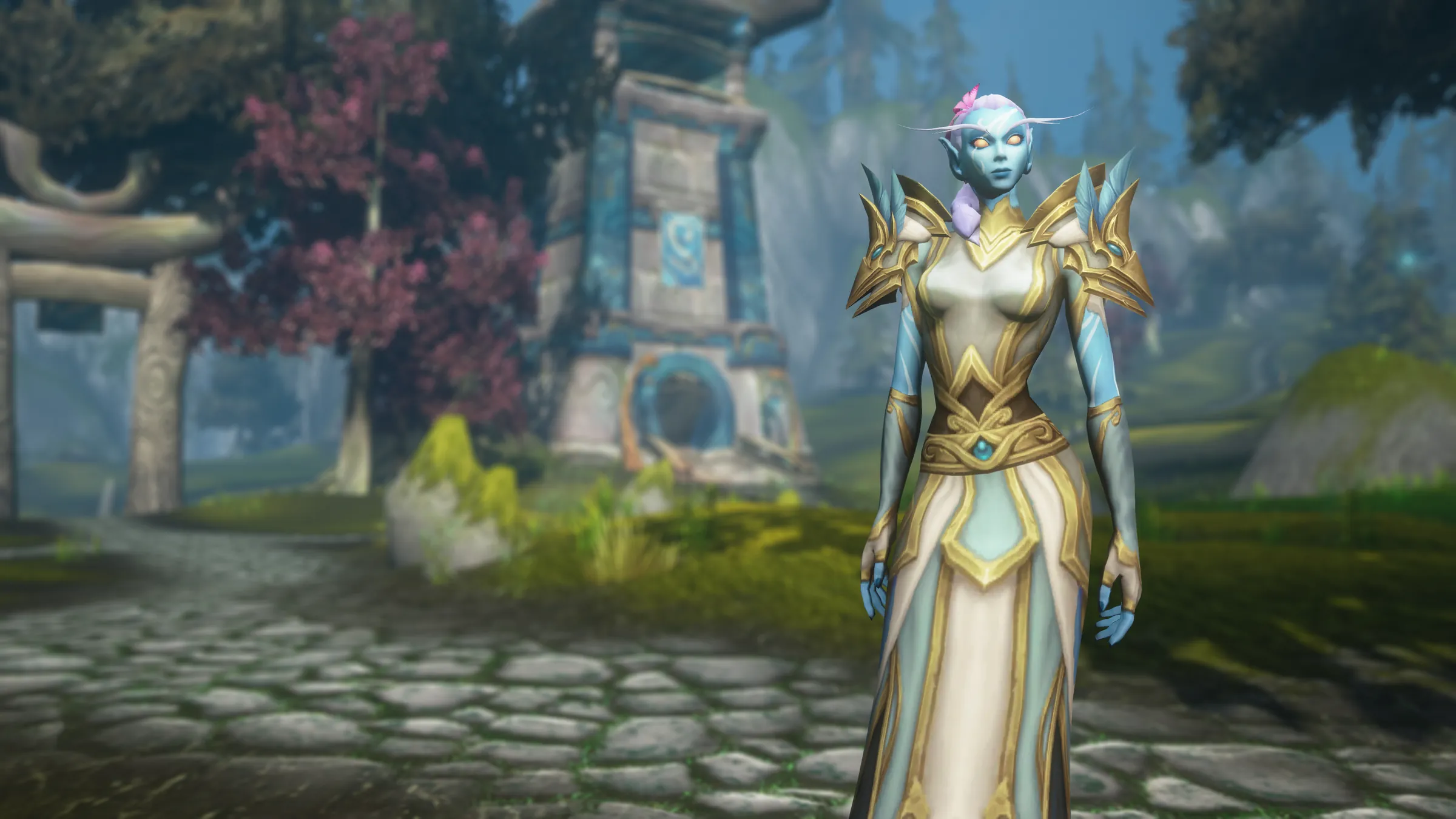 A Skyborne elf in white and gold robes beside a blue stone shrine